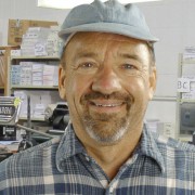 Man with salt-and-pepper goatee and beard in a print shop